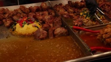 Usta bir şef kızarmış domuz kaburgalarını kızgın yağdan ayırır.