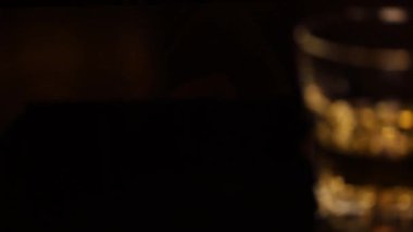 Siyah arka planda yavaş çekimde bir bardak alkol.