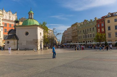 17 Nisan 2025 Krakow, Polonya, Eski şehrin ana pazar meydanı güneşli bir günde güzel binalar.