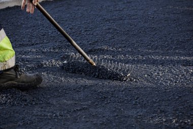 Şehirdeki asfalt araçlar ve üniformalarla çalışan operatörler