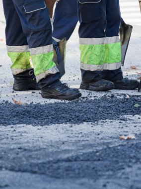 Asfalt yol inşaatında çalışan işçi botları