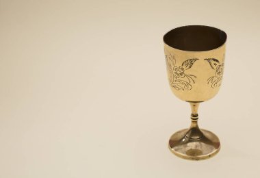 Sarı arka planda güzel altın bir kadeh