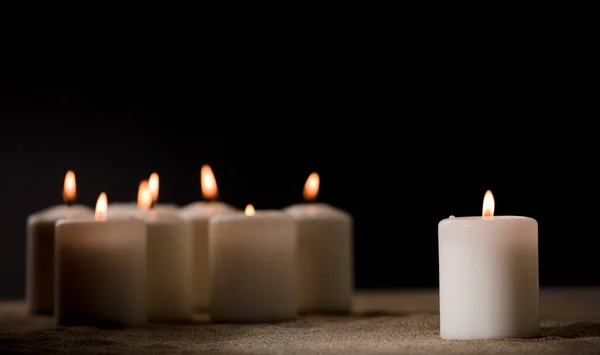 霸凌的概念 由一群点燃的蜡烛组成 在沙滩上 黑色的夜晚背景 — 图库照片