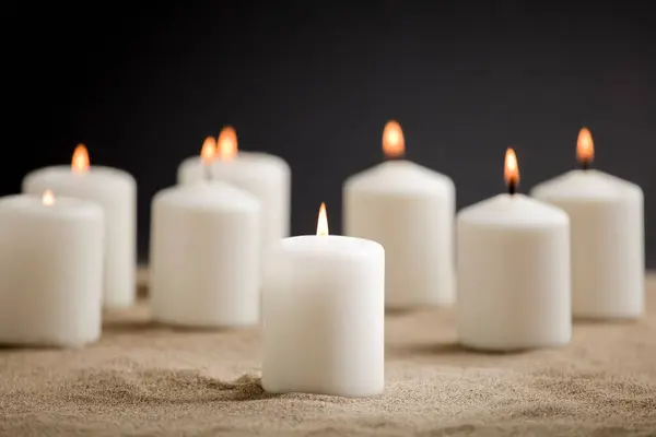 Kerzen Mit Brennender Flamme Sand lizenzfreie Stockbilder