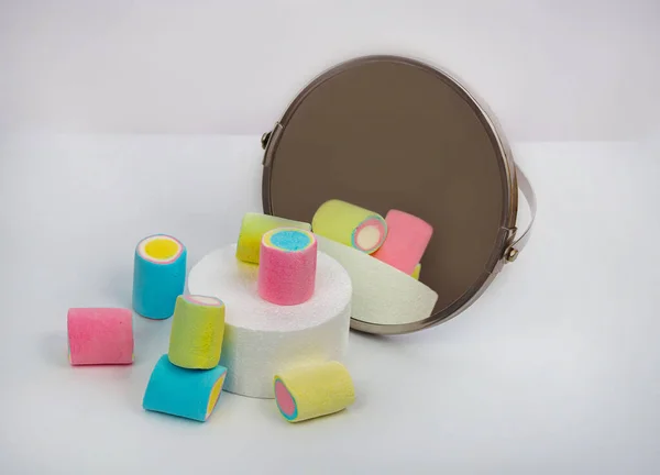 Aynanın önünde podyumda şekerlemeler ve beyaz masada diğerleri