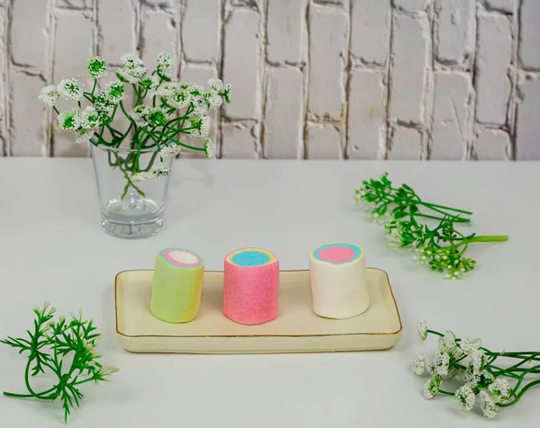 Beyaz arkaplanda seramik dikdörtgen tabakta renkli şekerlemeler