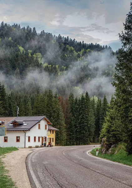 Dağların eteklerinde evleri olan muhteşem bir sabah sisi olan dağ manzarası..