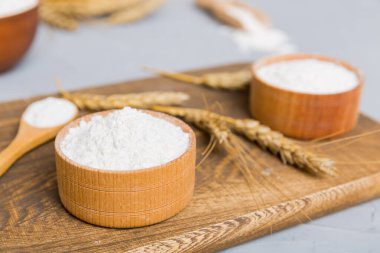 Tahta kasede buğday unu ve renkli arka planda buğday dikenleri. dünya buğday krizi.