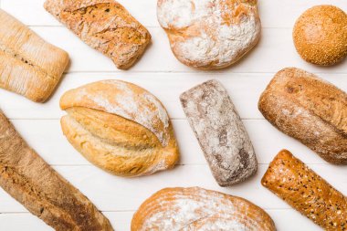 Ev yapımı doğal ekmek. Arka plan olarak farklı taze ekmek türleri, kopya alanı ile üst görünüm.