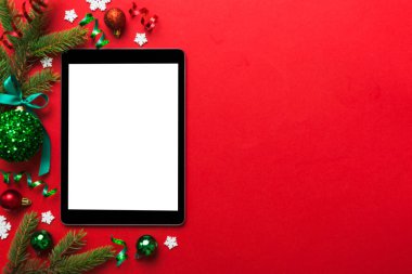 Digital tablet mock up with rustic Christmas decorations for app presentation top view with empty space for you design. Christmas online shopping concept. Tablet with copy space on colored background.