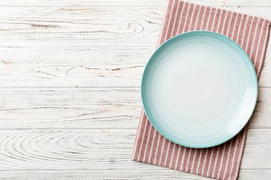 Renkli arkaplanda üst görünüm yiyecek için mavi tabak üzerinde boş. Tasarımınız için boşluk olan peçeteye boş tabak.