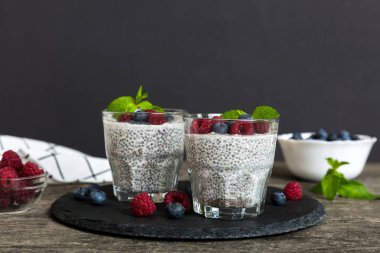 Sağlıklı kahvaltı ya da sabah chia tohumlu vanilyalı puding ahududu ve böğürtlen, vejetaryen gıda, diyet ve sağlık konsepti. Ahududu ve yabanmersinli Chia pudingi..