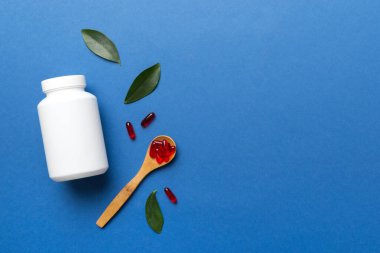 farklı ilaçlar ve ilaç şişesi sağlık hizmeti ve tıbbi destek hapları. Vitamin hapları. Masa arkasında renkli haplar olan bir şişe. Multivitaminler.