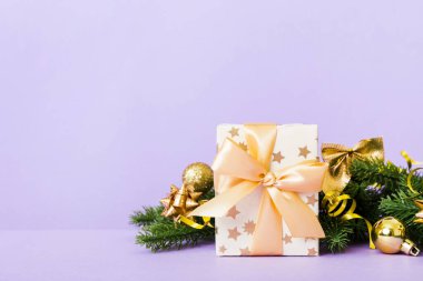 New Year Christmas mood, gift box, branches of a christmas tree, New Year decorations on a colored background.