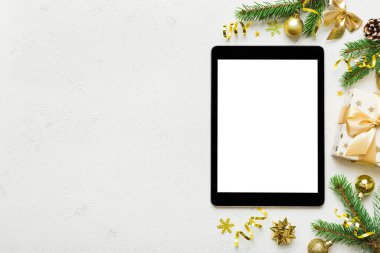 Digital tablet mock up with rustic Christmas decorations for app presentation top view with empty space for you design. Christmas online shopping concept. Tablet with copy space on colored background.