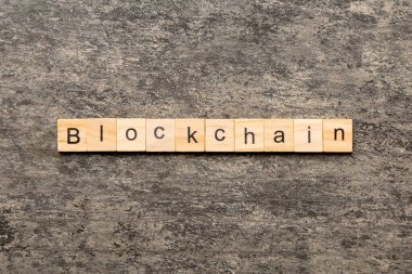 Tahta blokta bloklama kelimesi yazılı. Tablo üzerinde BLOCKCHAIN metni, konsept.