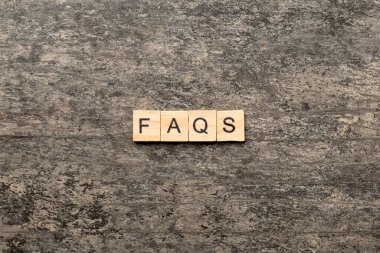 Tahta bloğa yazılmış faqqs kelime. Masada faqs metin, konsept.