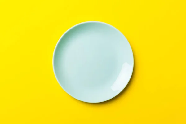 食品のための色の背景の空のラウンドブループレートの分離のトップビュー あなたのデザインのためのスペースと空の料理 — ストック写真