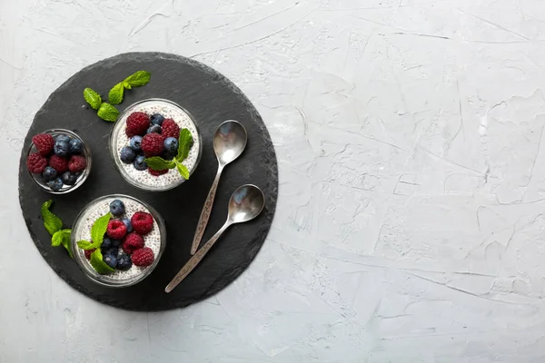 stock image Healthy breakfast or morning with chia seeds vanilla pudding raspberry and blueberry berries on table background, vegetarian food, diet and health concept. Chia pudding with raspberry and blueberry.