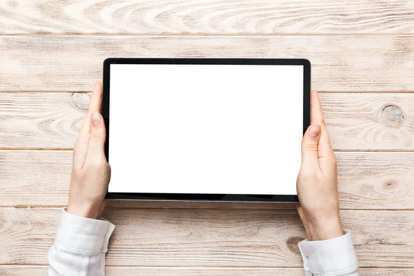 stock image female teen hands using tablet pc with white screen, Mockup image of woman hand holding white tablet pc with blank white screen at home.