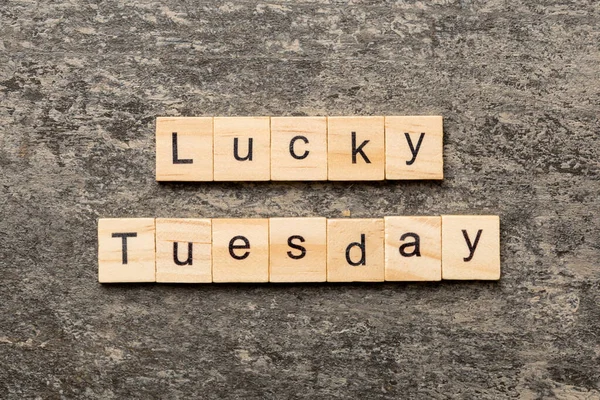 lucky Tuesday word written on wood block. lucky Tuesday text on cement table for your desing, concept.