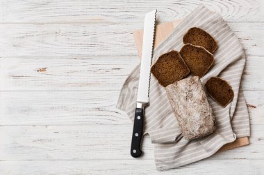 Tahtada bıçakla kesilmiş taze pişmiş ekmek. Üst manzara Dilimlenmiş ekmek ve bıçak.