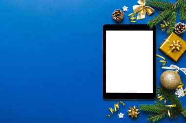 Digital tablet mock up with rustic Christmas decorations for app presentation top view with empty space for you design. Christmas online shopping concept. Tablet with copy space on colored background.