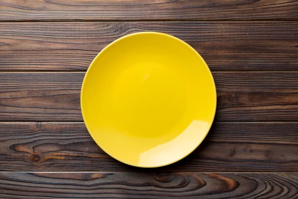 stock image Top view of empty yellow plate on wooden background. Empty space for your design.