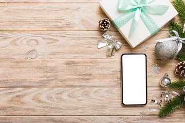 Digital phone mock up with rustic Christmas decorations for app presentation top view with empty space for you design. Christmas online shopping concept. Tablet with copy space on colored background.