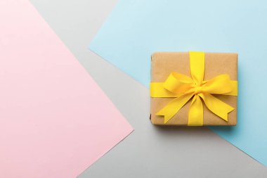 holiday paper present tied yellow ribbon bow top view with copy space. Flat lay holiday background. Birthday or christmas present. Christmas gift box concept with copy space.