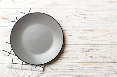 Renkli arka planda üst görünüm yiyecek için masa örtüsü üzerindeki boş yuvarlak gri tabak. Tasarımınız için boşluk olan peçeteye boş tabak.
