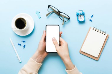 Mesajınız veya bilgi içeriğiniz için boş bir kopya ekranı olan akıllı telefonları tutan kadın ellerinin üst görünümü. üst görünümde telefon beyaz ekranı kullanan kadın eli.