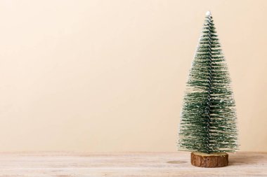 One small Christmas tree on colored background. new year decoration with copy space.