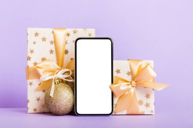 Digital phone mock up with rustic Christmas decorations for app presentation with empty space for you design. Christmas online shopping concept. Tablet with copy space on colored background.