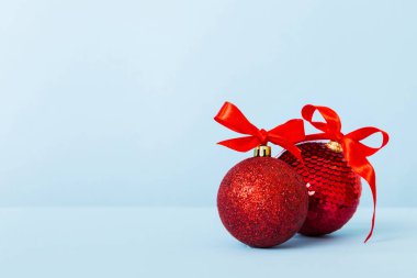 Christmas ball on colored background. decoration bauble with ribbon bow with copy space.