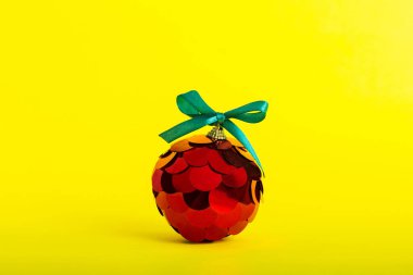 Christmas ball on colored background. decoration bauble with ribbon bow with copy space.