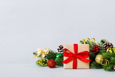 New Year Christmas mood, gift box, branches of a christmas tree, New Year decorations on a colored background.