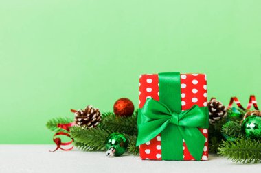 New Year Christmas mood, gift box, branches of a christmas tree, New Year decorations on a colored background.