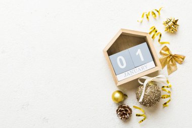 Christmas calendar 1 january. Christmas gift, fir branches, pine cones. Flat lay, top view. New Year decorations on a colored background.