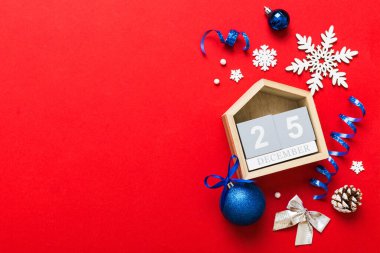 Christmas calendar 25 december. Christmas gift, fir branches, pine cones. Flat lay, top view. New Year decorations on a colored background.