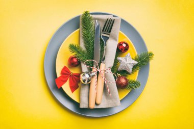 Noel süsleri, tabaklar, inekler, çatallar ve kaşıklarla Noel sofrası. Noel tatili geçmişi. Kopyalama alanı olan üst görünüm.