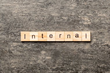 Tahta bloğa yazılmış interternal kelime. Çimento sehpası üzerindeki InterTERNAL metin desing, konsept.