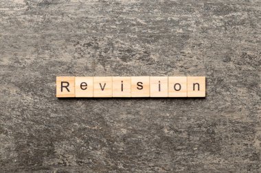 revision word written on wood block. revision text on table, concept.