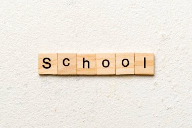 Tahta bloğa yazılmış okul kelimesi. Okul metni çimento üzerinde desing, konsept için.