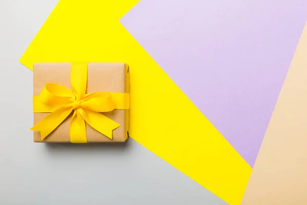 stock image holiday paper present tied yellow ribbon bow top view with copy space. Flat lay holiday background. Birthday or christmas present. Christmas gift box concept with copy space.