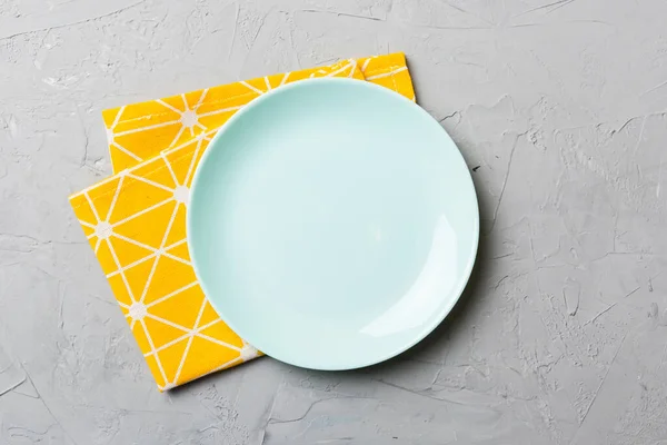 食べ物のためのテーブルクロスの色の背景空のラウンドブループレートの上のビュー あなたのデザインのためのスペースとナプキンに空の料理 — ストック写真