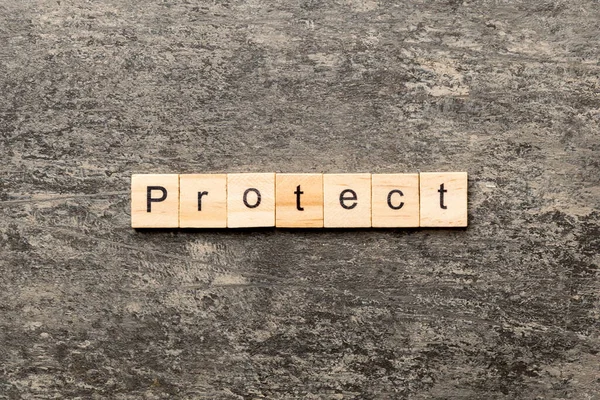 Proteger Palabra Escrita Bloque Madera Proteger Texto Mesa Cemento Para —  Fotos de Stock