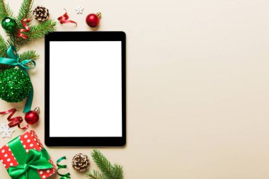 Digital tablet mock up with rustic Christmas decorations for app presentation top view with empty space for you design. Christmas online shopping concept. Tablet with copy space on colored background.