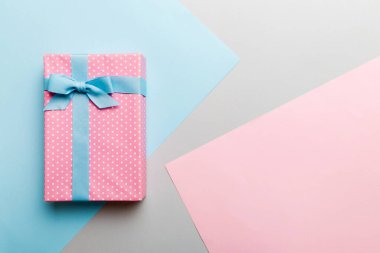 holiday handmade paper present tied blue ribbon bow top view with copy space. Flat lay holiday background. Birthday or christmas present. Christmas gift box concept with copy space.