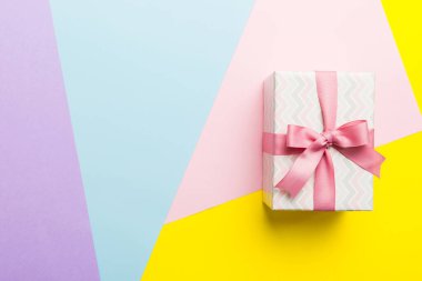 holiday paper present tied pink ribbon bow top view with copy space. Flat lay holiday background. Birthday or christmas present. Christmas gift box concept with copy space.